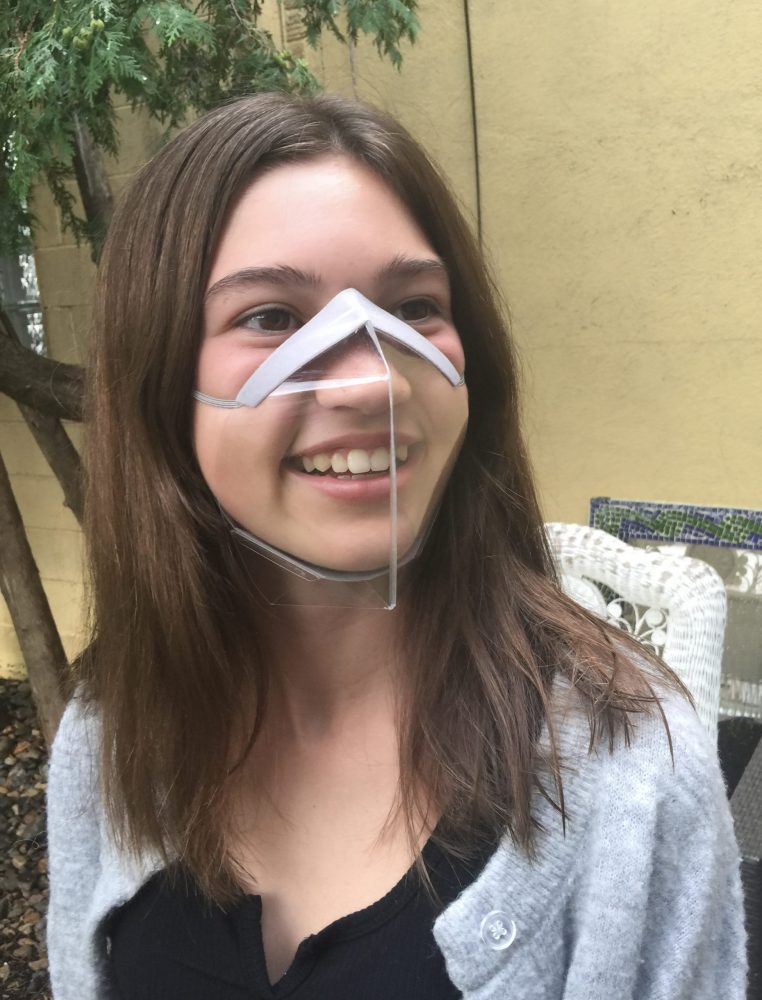Jeune fille souriante avec un masque transparent